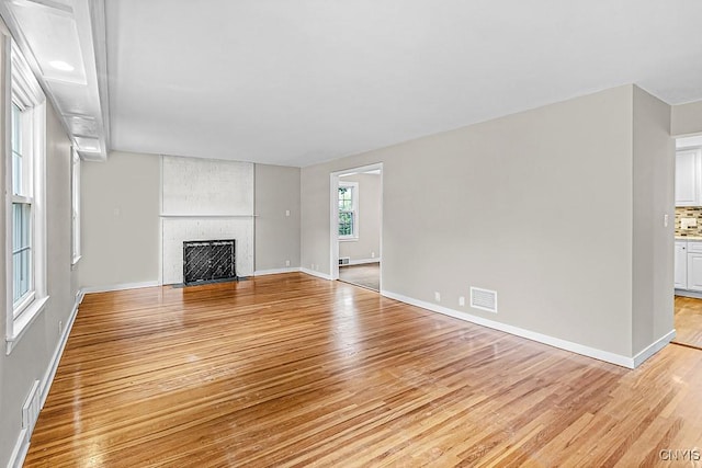 5 Glencrest Blvd, New Hartford, NY 13413 - unfurnished living room featuring light wood finished floors, a large fireplace, and baseboards