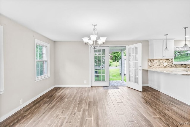 5 Glencrest Blvd, New Hartford, NY 13413 - unfurnished dining area with light wood-style floors, baseboards, a chandelier, and a sink