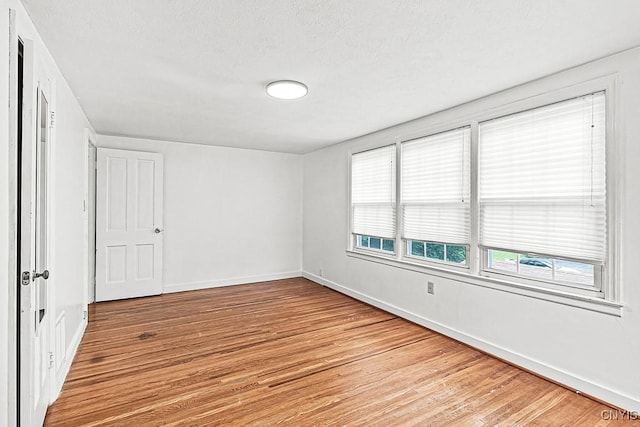 5 Glencrest Blvd, New Hartford, NY 13413 - unfurnished bedroom featuring light wood-type flooring, baseboards, multiple windows, and a textured ceiling