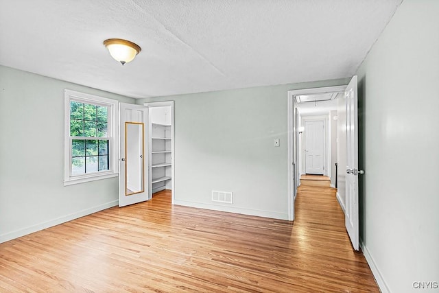 5 Glencrest Blvd, New Hartford, NY 13413 - unfurnished bedroom with wood finished floors, baseboards, attic access, and a textured ceiling