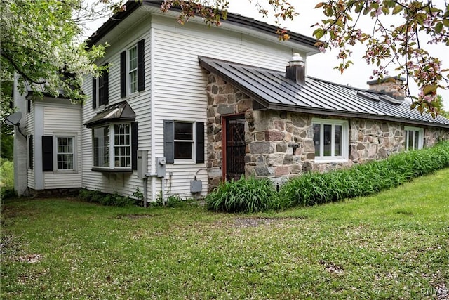 1466 Grant Rd, Russia, NY 13324 - rear view of property with a standing seam roof, stone siding, a chimney, and a lawn