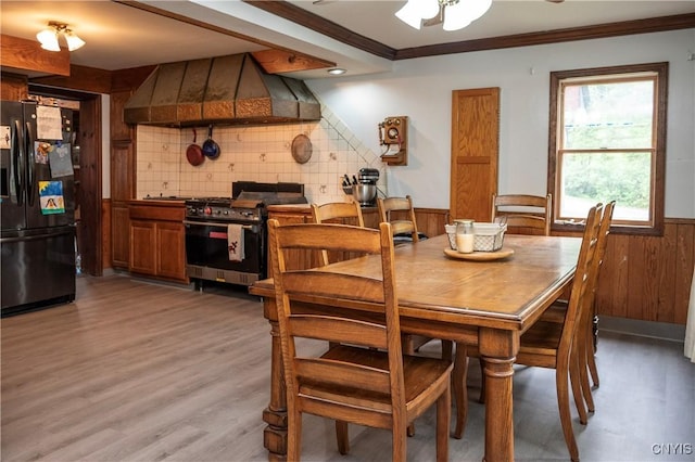 1466 Grant Rd, Russia, NY 13324 - dining space with ornamental molding, wainscoting, light wood-type flooring, ceiling fan, and wood walls