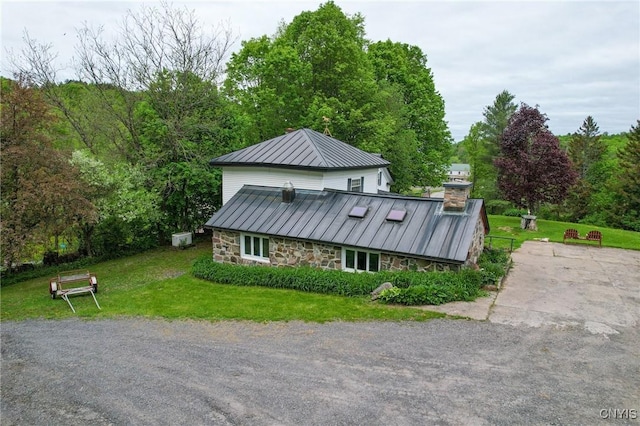 1466 Grant Rd, Russia, NY 13324 - view of front of property featuring stone siding, metal roof, a chimney, a front yard, and a standing seam roof