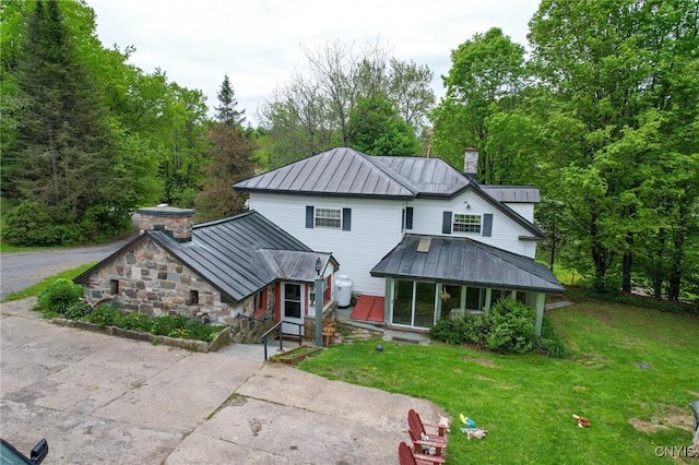 1466 Grant Rd, Russia, NY 13324 - view of front of home with a standing seam roof, metal roof, a chimney, a front lawn, and asphalt driveway