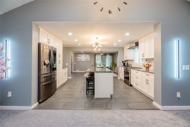 25 San Mateo Rd, Chili, NY 14624 - kitchen with appliances with stainless steel finishes, wall chimney exhaust hood, a kitchen bar, white cabinetry, and an island with sink