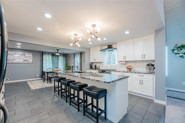 25 San Mateo Rd, Chili, NY 14624 - kitchen with wall chimney exhaust hood, a sink, ceiling fan, stone countertops, and backsplash