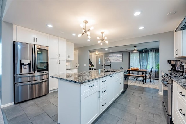 25 San Mateo Rd, Chili, NY 14624 - kitchen featuring stainless steel appliances, a sink, a chandelier, dark stone countertops, and a center island with sink