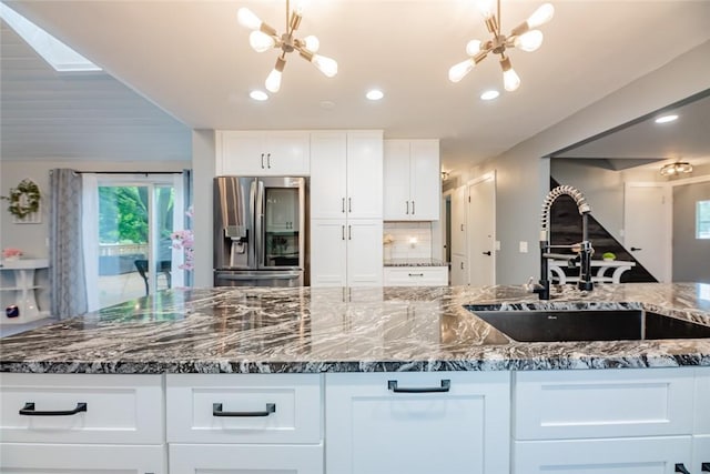 25 San Mateo Rd, Chili, NY 14624 - kitchen with stainless steel fridge, a sink, a chandelier, dark stone countertops, and white cabinets