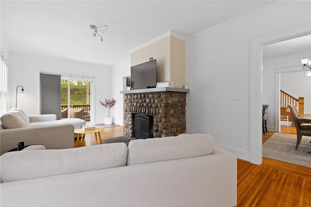 224 Lyell Ave, Ogden, NY 14559 - living room with wood finished floors, a fireplace, crown molding, and stairway