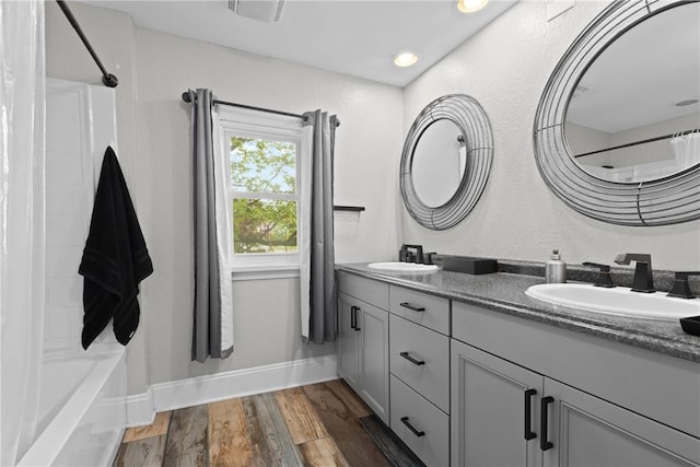 224 Lyell Ave, Ogden, NY 14559 - full bath featuring double vanity, wood finished floors, baseboards, and shower / bathtub combination with curtain