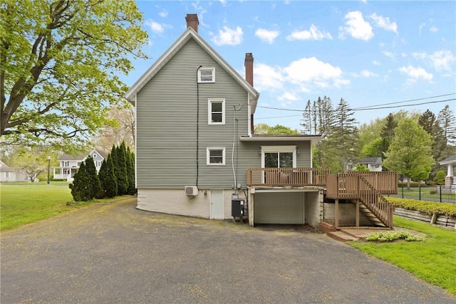 224 Lyell Ave, Ogden, NY 14559 - rear view of house with a wooden deck, an attached garage, stairway, driveway, and a chimney