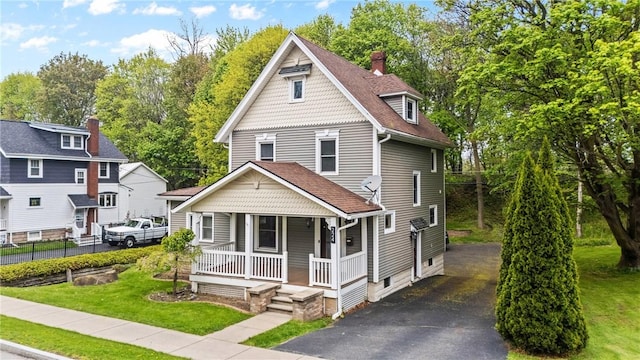 224 Lyell Ave, Ogden, NY 14559 - victorian-style house with covered porch, asphalt driveway, roof with shingles, and a chimney