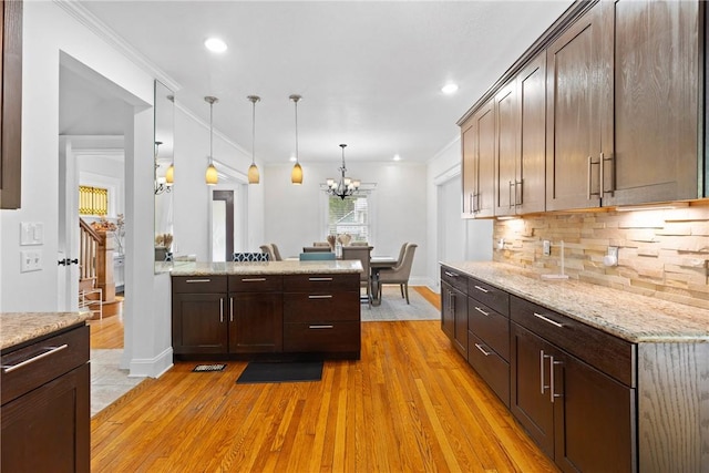 224 Lyell Ave, Ogden, NY 14559 - kitchen with light wood-style flooring, decorative backsplash, a chandelier, pendant lighting, and light stone countertops