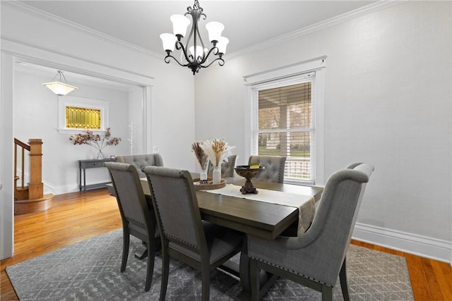 224 Lyell Ave, Ogden, NY 14559 - dining area with a chandelier, wood finished floors, baseboards, stairway, and crown molding