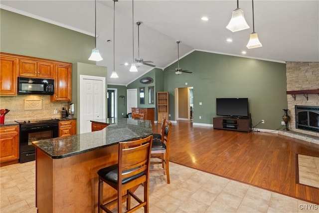 484 Chesbro Rd, Schroeppel, NY 13132 - kitchen with black appliances, brown cabinetry, a kitchen bar, open floor plan, and a center island