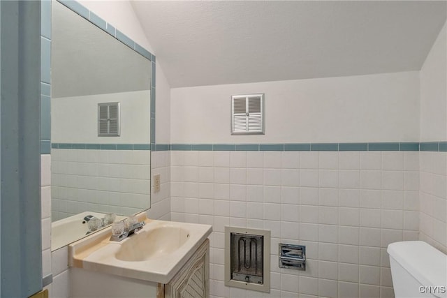 329 Hazelhurst Ave, Syracuse, NY 13206 - half bath featuring tile walls, toilet, vanity, and wainscoting