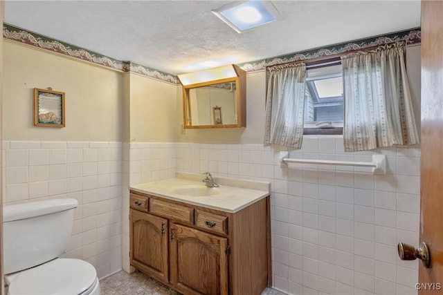 329 Hazelhurst Ave, Syracuse, NY 13206 - bathroom with tile walls, toilet, vanity, and wainscoting