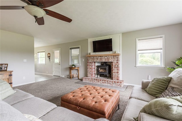 2935 Main St, York, NY 14533 - carpeted living area with baseboards, a wood stove, and ceiling fan