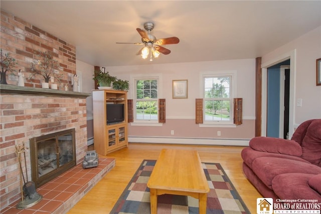10280 Christy Rd, Sheridan, NY 14063 - living area featuring light wood-type flooring, a baseboard heating unit, a brick fireplace, and a ceiling fan
