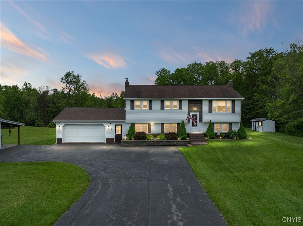 4965 Jenkins Rd, Westmoreland, NY 13476 - split foyer home with a chimney, an attached garage, driveway, and a lawn