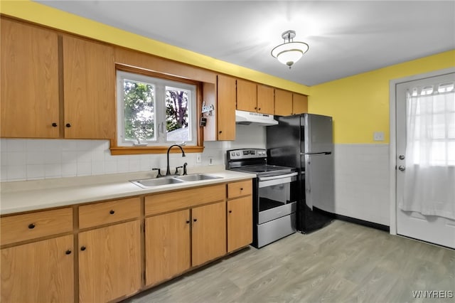 7514 Stephenson Ave, Niagara Falls, NY 14304 - kitchen with stainless steel range with electric stovetop, a sink, under cabinet range hood, plenty of natural light, and wainscoting