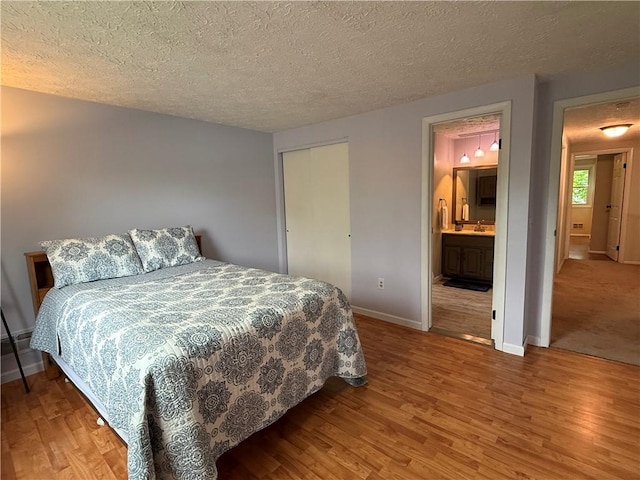 300 Amy Ln, Clarkson, NY 14420 - bedroom with wood finished floors, baseboards, a textured ceiling, a sink, and a closet