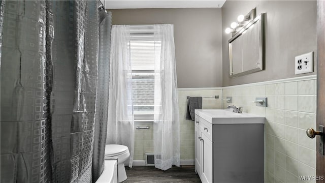 35 Duerstein St, Buffalo, NY 14210 - bathroom with tile walls, toilet, vanity, wood finished floors, and wainscoting