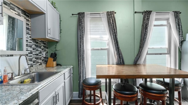 35 Duerstein St, Buffalo, NY 14210 - kitchen with a sink, backsplash, stainless steel dishwasher, light countertops, and white cabinets