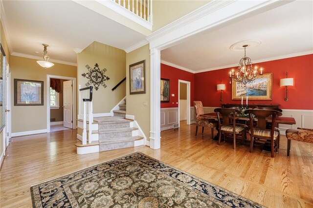72 Meadow Cove Rd, Pittsford, NY 14534 - dining area with wood finished floors, stairs, crown molding, wainscoting, and a chandelier