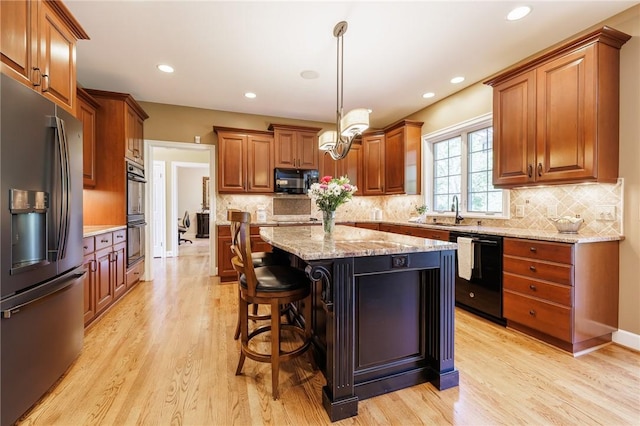 72 Meadow Cove Rd, Pittsford, NY 14534 - kitchen with black appliances, light wood-type flooring, brown cabinets, a sink, and recessed lighting