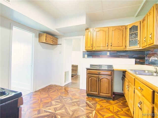 40 Federal Ave, Buffalo, NY 14215 - kitchen with a sink, glass insert cabinets, brown cabinetry, and light countertops