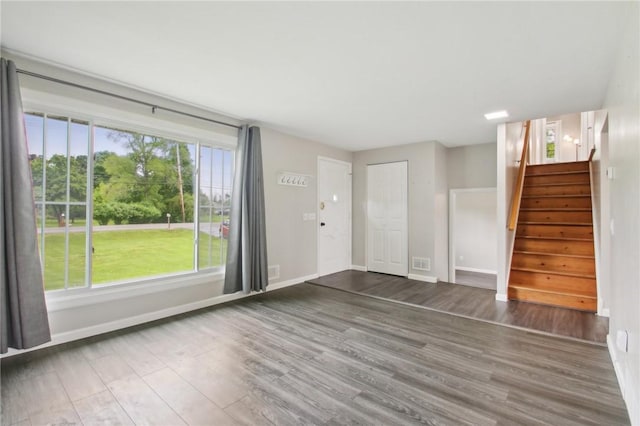 1099 N Greece Rd, Greece, NY 14626 - unfurnished living room with stairs, wood finished floors, and baseboards