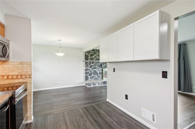 1099 N Greece Rd, Greece, NY 14626 - kitchen with stainless steel appliances, a stone fireplace, white cabinets, baseboards, and dark wood-style flooring