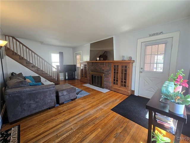 116 Mariposa St, Syracuse, NY 13206 - living area with wood-type flooring, stairway, healthy amount of natural light, and a brick fireplace