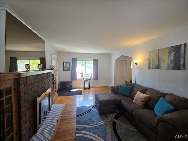 116 Mariposa St, Syracuse, NY 13206 - living room featuring a fireplace, wood finished floors, arched walkways, baseboards, and crown molding