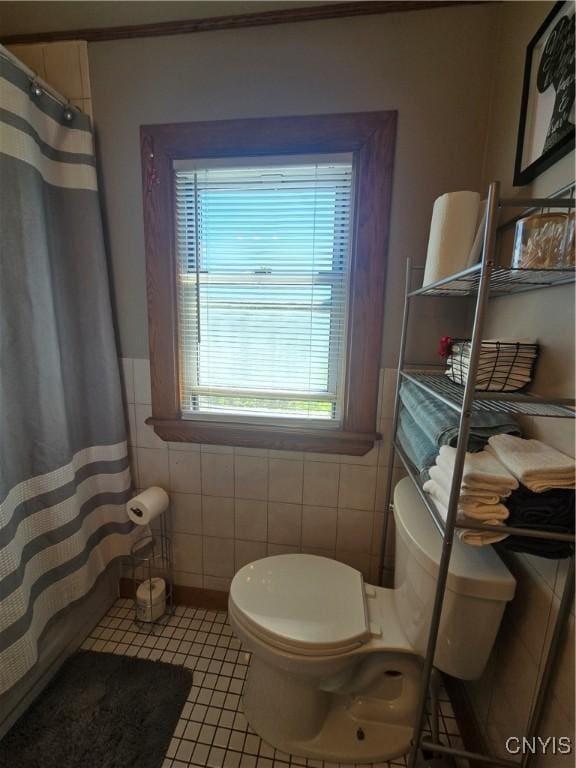 116 Mariposa St, Syracuse, NY 13206 - bathroom featuring tile walls, toilet, tile patterned floors, a shower with shower curtain, and a wainscoted wall