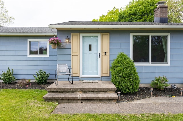 25 Selkirk Dr, Greece, NY 14626 - view of exterior entry featuring a chimney and a shingled roof