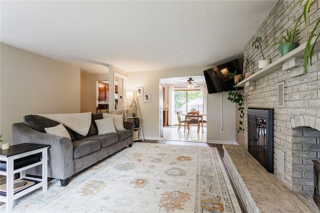 25 Selkirk Dr, Greece, NY 14626 - living area featuring a fireplace, a textured ceiling, a ceiling fan, baseboards, and wood finished floors