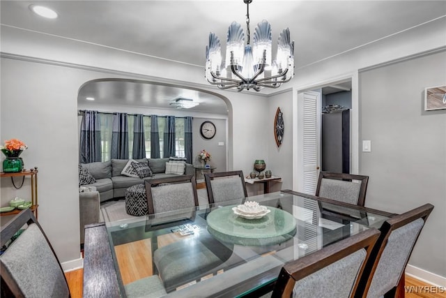 1597 Kensington Ave, Cheektowaga, NY 14215 - dining space with arched walkways, a chandelier, baseboards, wood finished floors, and recessed lighting