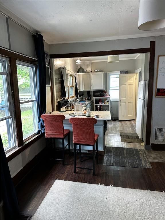 386 Westfield St, Rochester, NY 14619 - dining area featuring healthy amount of natural light, wood finished floors, crown molding, and baseboards