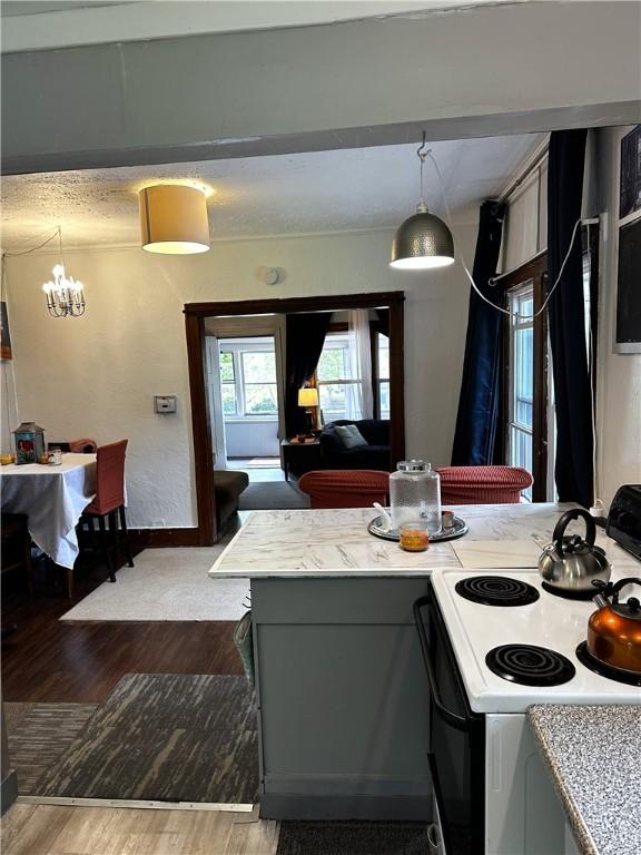 386 Westfield St, Rochester, NY 14619 - kitchen featuring white electric range oven, wood finished floors, a chandelier, light countertops, and hanging light fixtures
