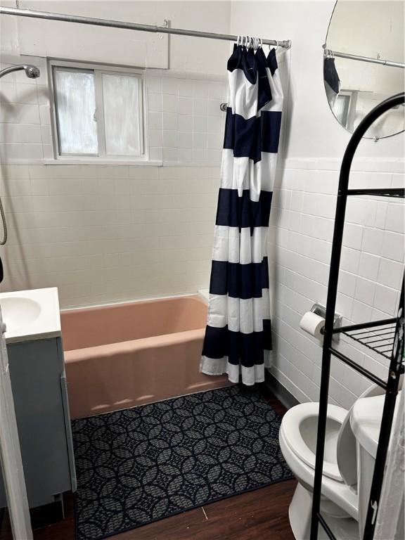 386 Westfield St, Rochester, NY 14619 - full bath featuring tile walls, toilet, wood finished floors, shower / bath combo, and vanity
