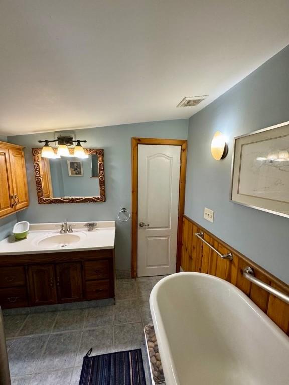 450 Stover Rd, Tyrone, NY 14815 - full bath with a freestanding bath, vanity, wainscoting, tile patterned flooring, and wood walls