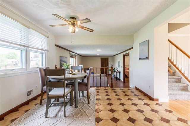 63 Shadywood Dr, Gates, NY 14606 - dining space with baseboards, a ceiling fan, stairs, a textured ceiling, and light flooring
