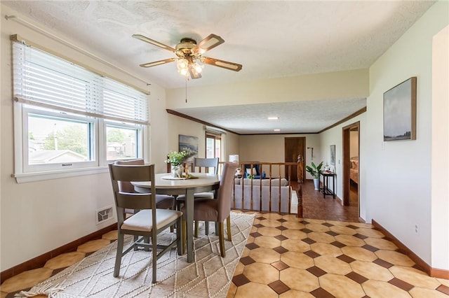 63 Shadywood Dr, Gates, NY 14606 - dining room with ceiling fan, baseboards, a textured ceiling, light floors, and crown molding