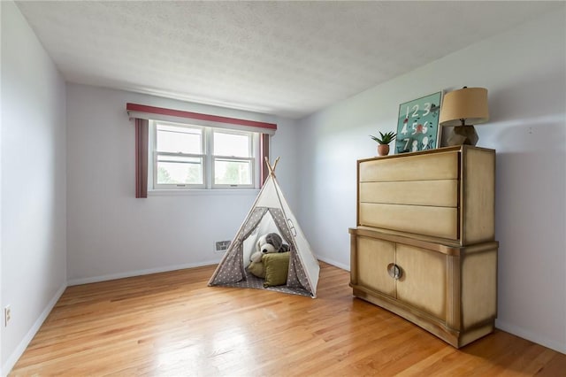 63 Shadywood Dr, Gates, NY 14606 - playroom with light wood-style floors, a textured ceiling, and baseboards