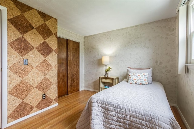 63 Shadywood Dr, Gates, NY 14606 - bedroom with wood finished floors, a closet, and wallpapered walls