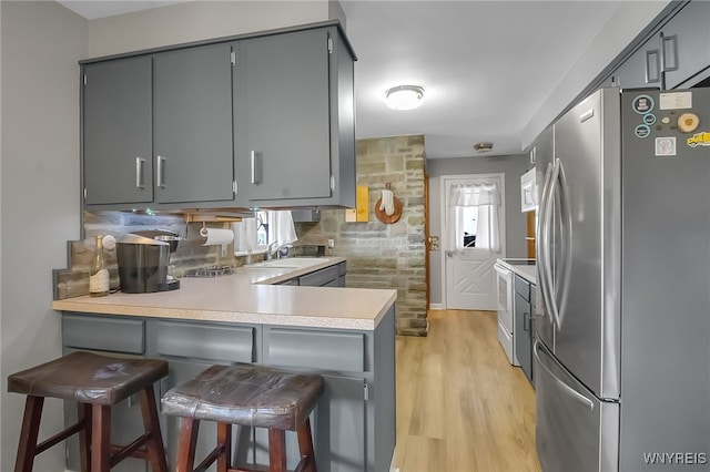 3955 Four Rod Rd Unit S, Marilla, NY 14052 - kitchen featuring white appliances, gray cabinetry, a sink, a peninsula, and light wood-style floors
