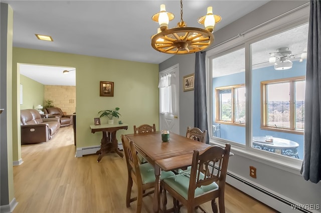 3955 Four Rod Rd Unit S, Marilla, NY 14052 - dining room featuring light wood-style flooring, a chandelier, and baseboard heating