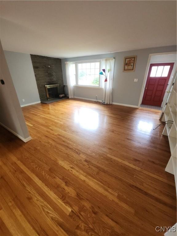 149 Robbins Ln, Dewitt, NY 13214 - unfurnished living room with wood finished floors, baseboards, and a fireplace